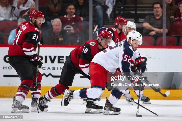 Emil Bemstrom of the Columbus Blue Jackets skates with the puck ahead of Michael Grabner of the Arizona Coyotes during the third period of the NHL...