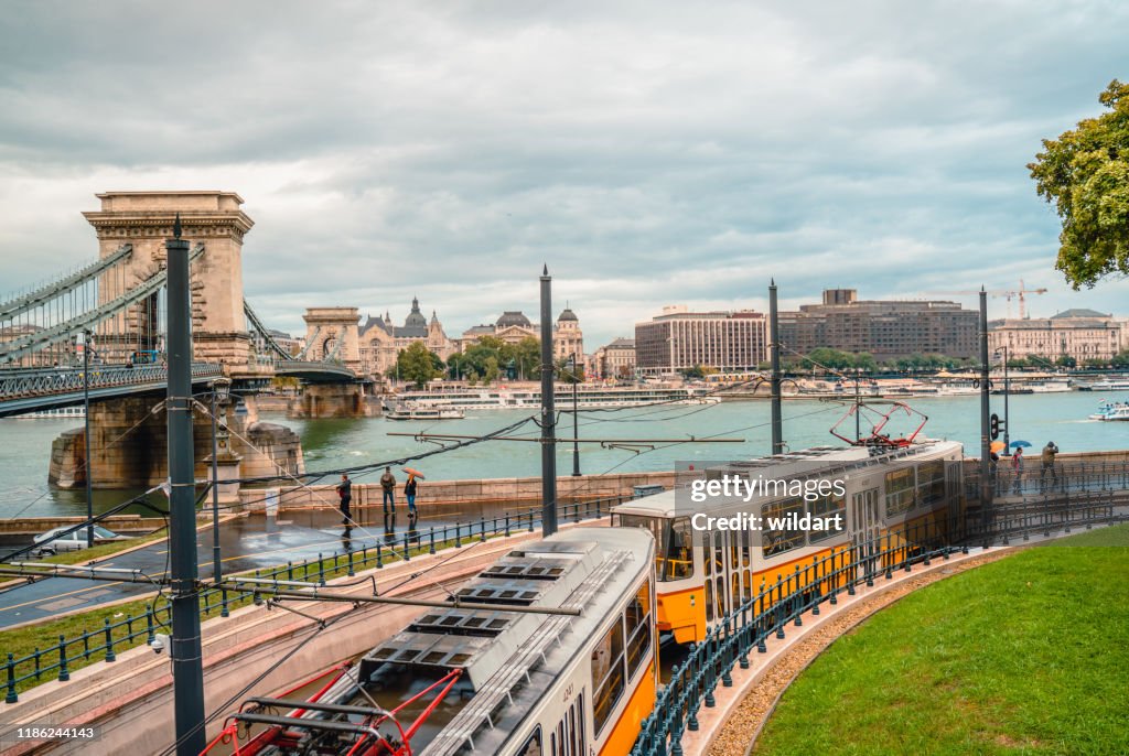 Old tram is going near Chain bridge in Danube river in Budapest