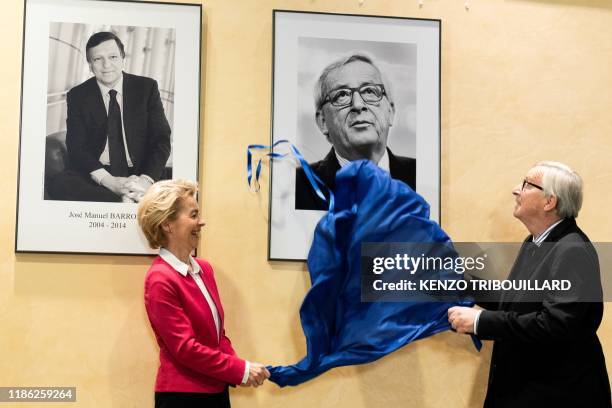 Outgoing European Commission President Jean-Claude Juncker unveils a picture of him with new European Commission President Ursula von der Leyen...