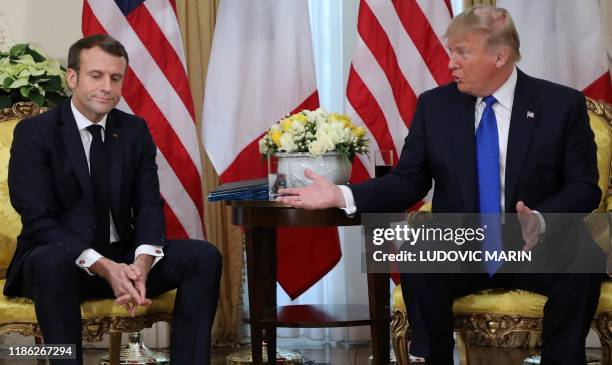 President Donald Trump and France's President Emmanuel Macron react as they talk during their meeting at Winfield House, London on December 3, 2019....