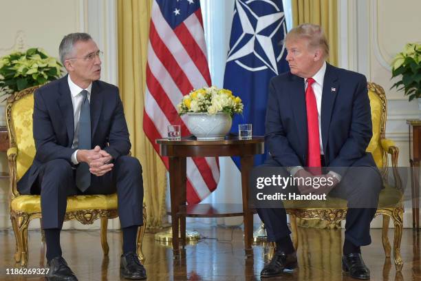In this handout provided by NATO, Jens Stoltenberg, Secretary General of NATO speaks with U.S. President Donald Trump ahead of the NATO Leaders...