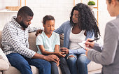 Little black girl and her parents at psychologist consultation