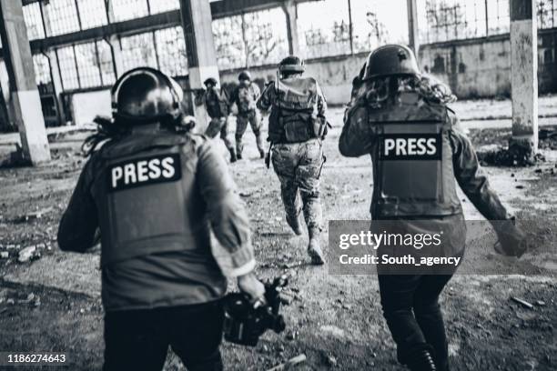 periodistas informando desde la zona de guerra - periodismo fotografías e imágenes de stock