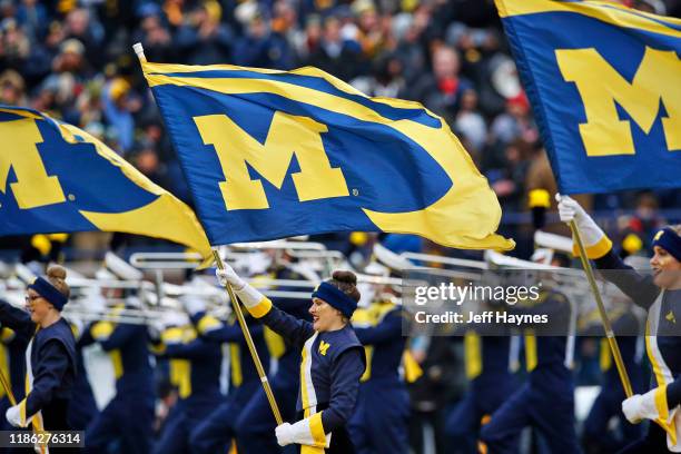 Michigan cheerleaders waving flags with team logo on field before game vs Ohio State at Michigan Stadium. Ann Arbor, MI CREDIT: Jeff Haynes