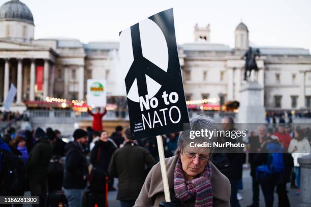 An activist carries an anti-NATO placard at a protest against NATO and US President Donald Trump in Trafalgar Square in London, England, on December...