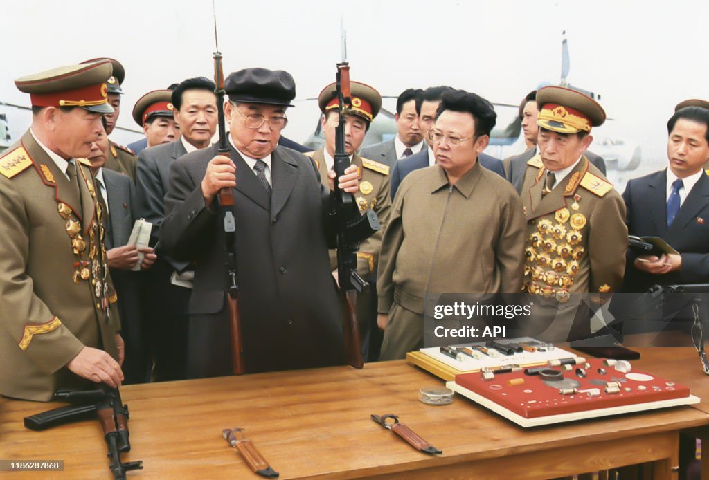 Kim Ilsung et Kim Jongil inspectant des fusils d'assaut de l'armée