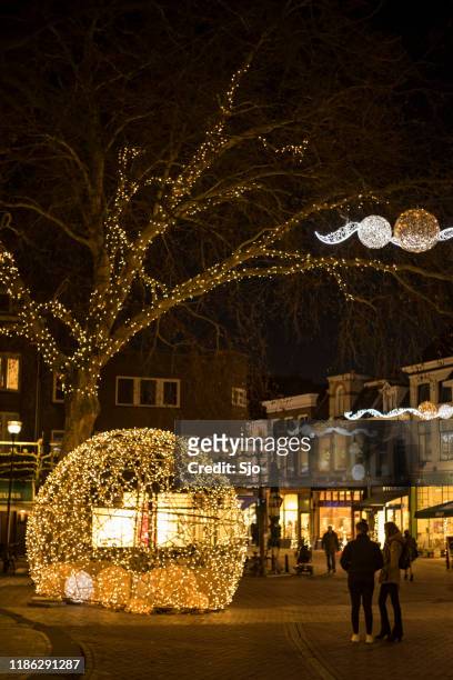 light sculpture in zwolle during winter with people looking at the lights in the street and tree - zwolle stock pictures, royalty-free photos & images
