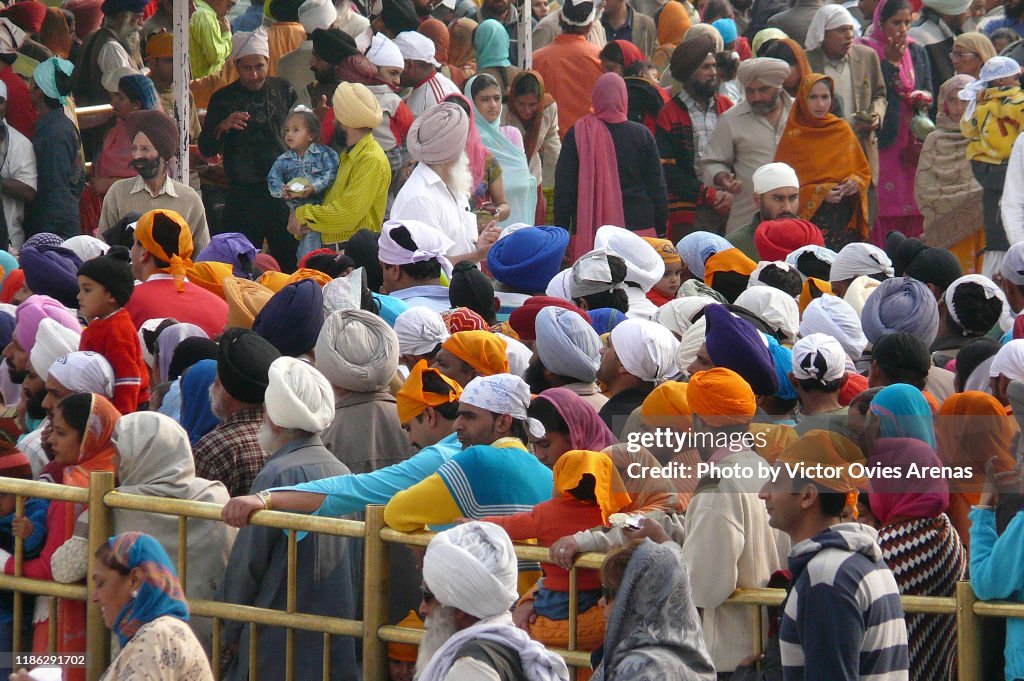 Large number of Pilgrims waiting to enter the Harmandir Sahib (The Golden Temple) and the clock tower in Amritsar, Punjab, India