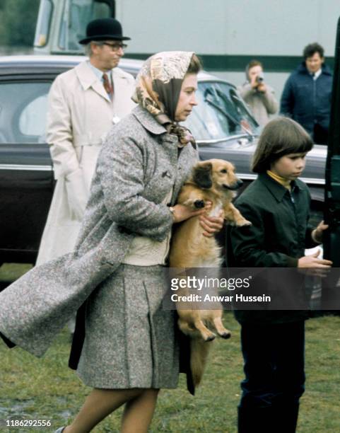 Queen Elizabeth II , accompanied by Lady Sarah Armstrong-Jones, carries one of her pet dogs at Windsor Great Park on May 01, 1977 in Windsor, England.