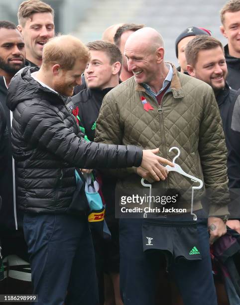Prince Harry, Duke of Sussex shares a joke with former Wales rugby captain, Gareth Thomas as he is presented with a Harlequins kit for son Archie...