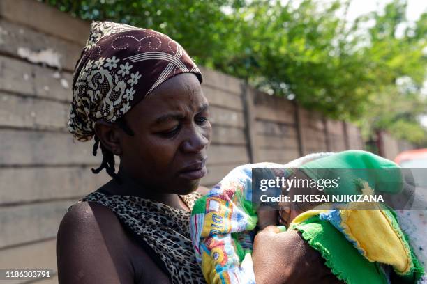 Winnie Denhere cradling her two-day-old baby boy delivered by Esther Gwena outside Edith Opperman clinic where the baby is to receive a BCG vaccine...