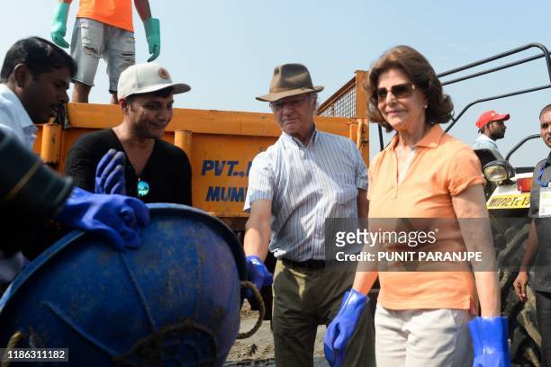 Sweden's King Carl XVI Gustaf and Queen Silvia participate in a beach clean-up project a the Versova Beach in Mumbai on December 4, 2019.