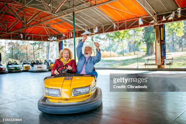 pretpark-senior paar in bumper car - crazy old people stockfoto's en -beelden