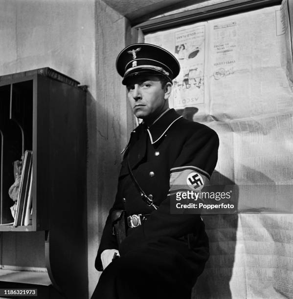 Austrian actor Paul Henreid in character as Captain Karl Marsen dressed in Nazi Gestapo police uniform during the shooting of a scene from the war...