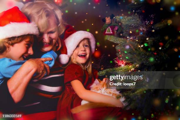 grandmother, grandson and granddaughter having fun at christmas - old man woman christmas stock pictures, royalty-free photos & images