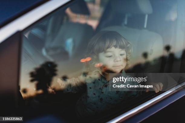 toddler boy in driver's seat of van looking at the sunset - car driver ストックフォトと画像