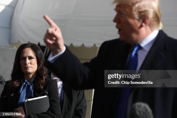 White House Press Secretary Stephanie Grisham listens to U.S. President Donald Trump talk to reporters before he boards Marine One and departing the...