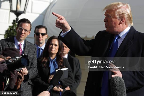 White House Deputy Press Secretary Judd Deere and Press Secretary Stephanie Grisham listen to U.S. President Donald Trump talk to reporters before he...