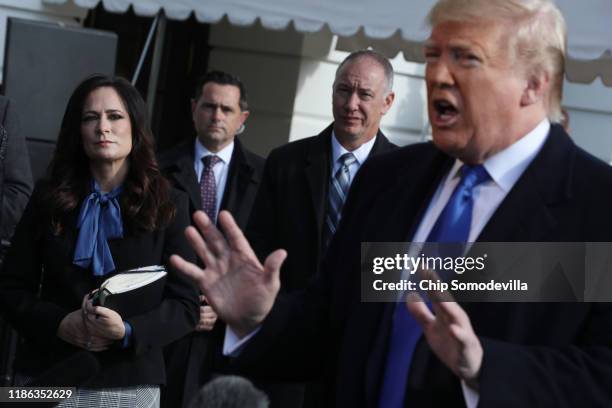 White House Press Secretary Stephanie Grisham listens to U.S. President Donald Trump talk to reporters before he boards Marine One and departing the...