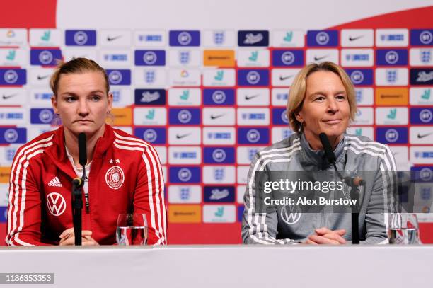 Martina Voss-Tecklenburg, Head Coach of Germany speaks to the media as Alexandra Popp of Germany looks on during a press conference on the eve of the...