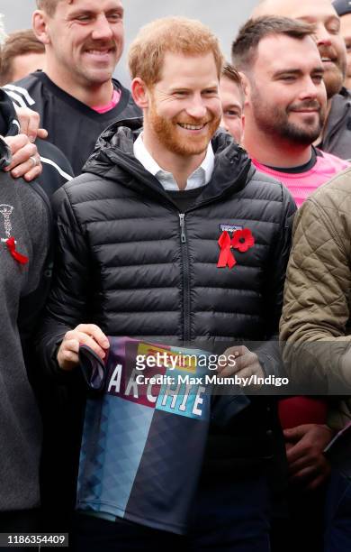 Prince Harry, Duke of Sussex is presented with a Harlequins rugby shirt for his baby son Archie Harrison Mountbatten-Windsor as he attends a Terrence...
