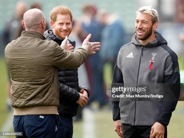 Prince Harry, Duke of Sussex and Gareth Thomas talk with Harlequins team captain Chris Robshaw as they attend a Terrence Higgins Trust event ahead of...