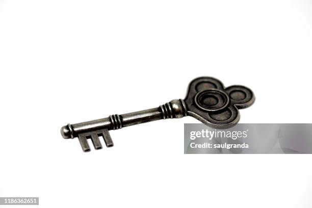 metallic key against white - old fashioned key stock pictures, royalty-free photos & images