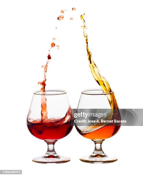 raising a toast of liquor glasses on a white background. - splashing cocktail stock pictures, royalty-free photos & images