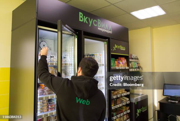 Worker selects an item from the refrigerated unit of a Vkusvill OOO self-service minimarket inside an office in Moscow, Russia, on Thursday, Nov. 21,...