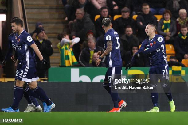 Gerard Deulofeu of Watford celebrates with his teammates after scoring his sides first goal during the Premier League match between Norwich City and...