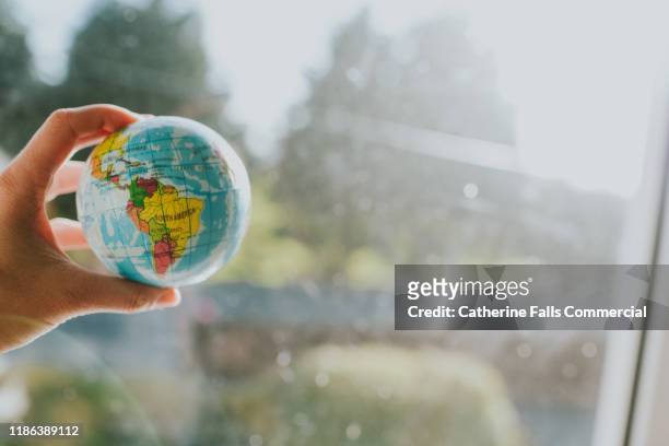 hand holding a globe - america latina fotografías e imágenes de stock