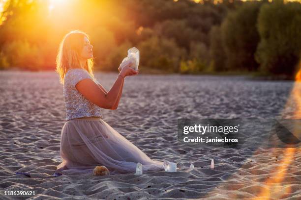 beautiful woman on beach holding healing crystals - healing crystals stock pictures, royalty-free photos & images
