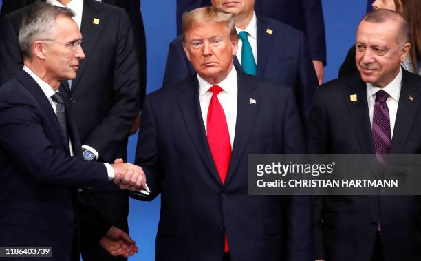 Secretary General Jens Stoltenberg shakes hands with US President Donald Trump , next to Turkey's President Recep Tayyip Erdogan , during a family...