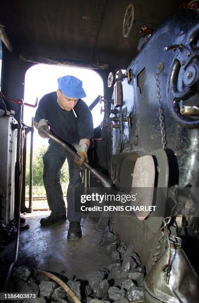 Un bénévole de l'association qui exploite le chemin de fer de le baie de Somme enfourne du charbon dans la chaudière de la locomotive à vapeur, le 11...
