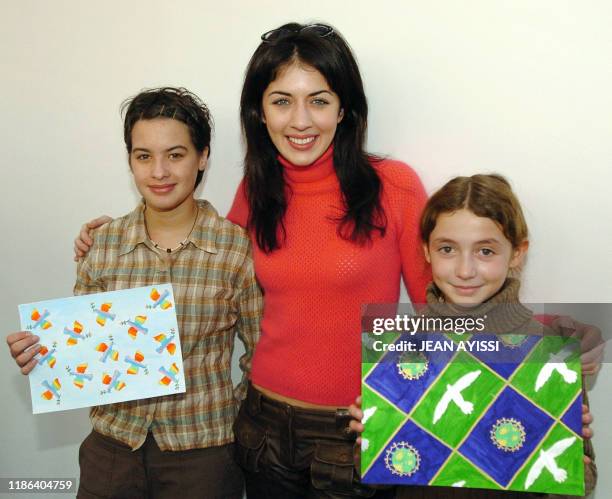 La chanteuse Nolwenn Leroy pose, le 15 janvier 2004 au siège de l'Unicef à Paris, avec Constance, 12 ans et Camille, 10 ans, qui présentent les...