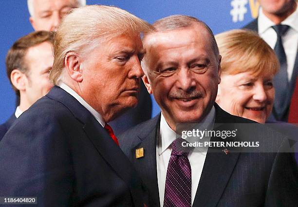 President Donald Trump and Turkey's President Recep Tayyip Erdogan leave the stage after the family photo to head to the plenary session at the NATO...