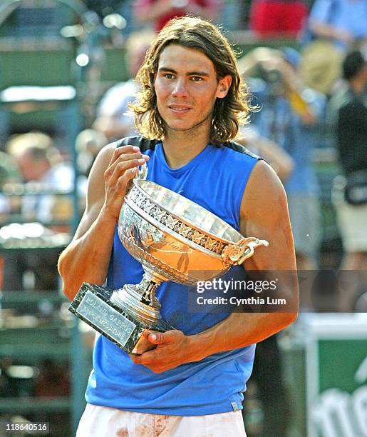 Spain's Rafael Nadal holds the championship trophy after defeating Roger Federer in the men's final of the 2006 French Open at Roland Garros, Paris,...