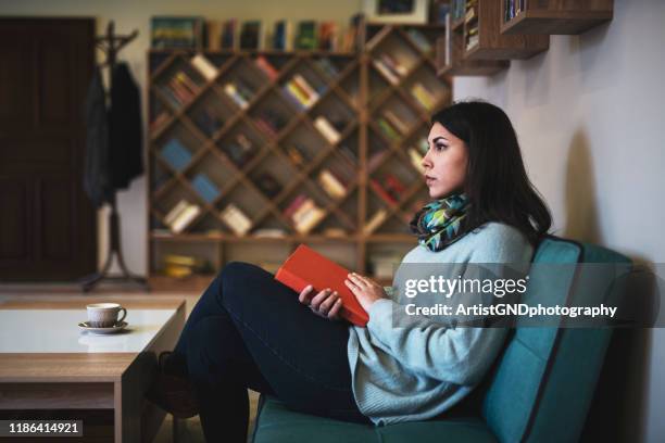 vrouw in de bibliotheek - eenheid stockfoto's en -beelden