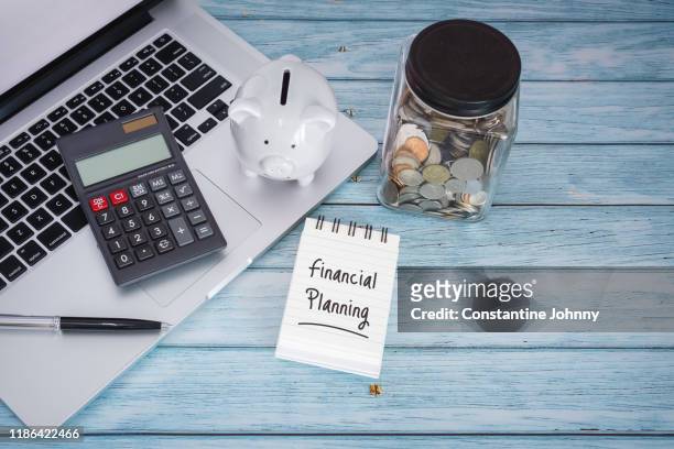 financial planning on notebook with laptop on wood background - tip jar stock pictures, royalty-free photos & images