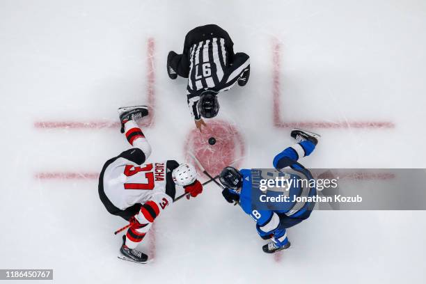 Pavel Zacha of the New Jersey Devils takes a second period face-off against Bryan Little of the Winnipeg Jets at the Bell MTS Place on November 5,...