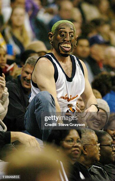 Fan wearing a Dennis Rodman mask leads the crowd in cheers during a timeout.