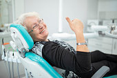 Old senior woman sitting in a dental chair
