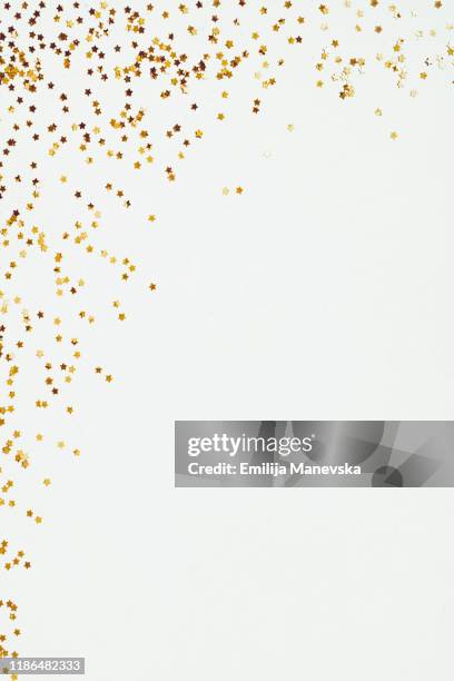 glittery yellow star confetti on white background - star confetti white background stockfoto's en -beelden