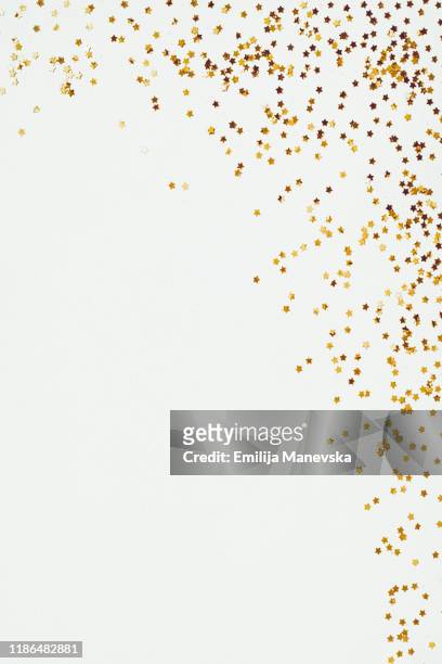 glittery yellow star confetti on white background - christmas frame stock-fotos und bilder
