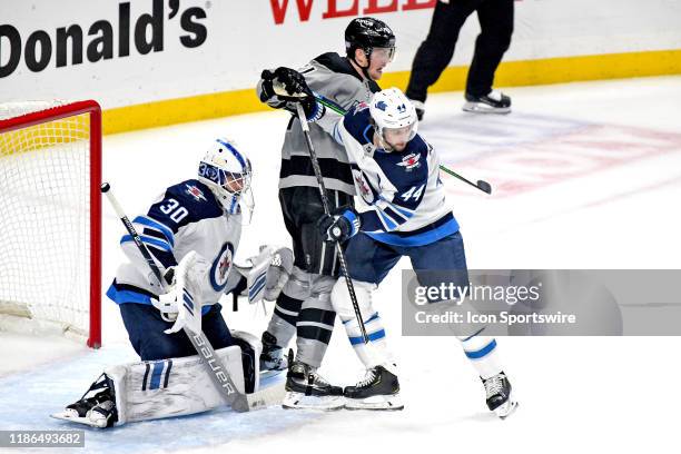 Los Angeles Kings Right Wing Austin Wagner battles for position in front of Winnipeg Jets Defenceman Josh Morrissey and Goalie Laurent Brossoit...