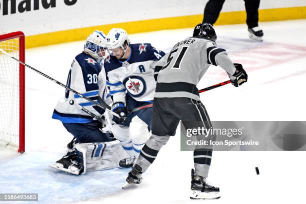 Los Angeles Kings Right Wing Austin Wagner battles for position in front of Winnipeg Jets Defenceman Josh Morrissey and Goalie Laurent Brossoit...