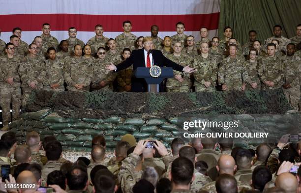 In this file photo taken on November 28 US President Donald Trump speaks to the troops during a surprise Thanksgiving day visit at Bagram Air Field...