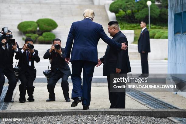 In this file photo taken on June 30 US President Donald Trump steps into the northern side of the Military Demarcation Line that divides North and...