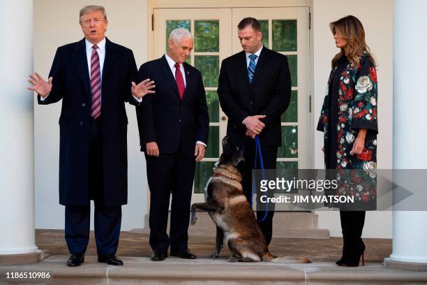 In this file photo taken on November 25 US President Donald Trump , Vice President Mike Pence and First Lady Melania Trump stand with Conan, the...