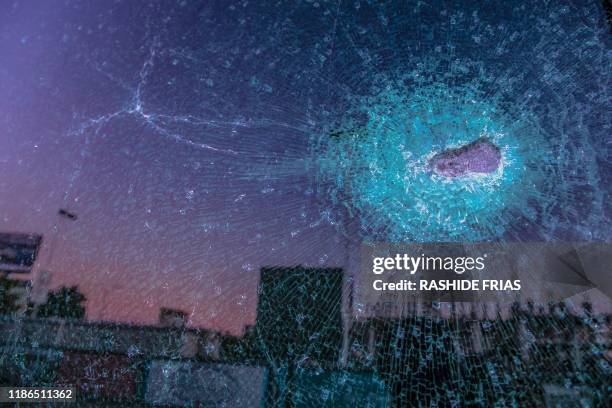 Graphic content / TOPSHOT - View of a glass hit by a bullet after a confrontation between armed men and the Mexican military due to the arrest of...